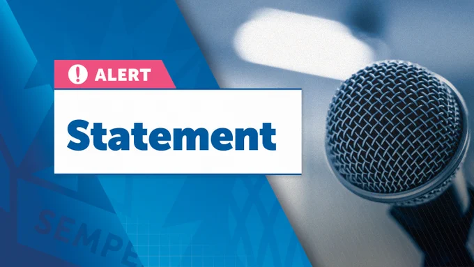 On the left side, a pink and white box with a warning icon and the word "ALERT" is prominently shown. Below this, a large white box contains the text "Statement" in bold blue letters. The right side of the image features a blue-tinted, slightly blurred photograph of a microphone, indicating an announcement or press release.