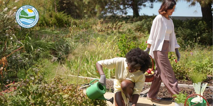 A woman and child plant fruits and vegetables.