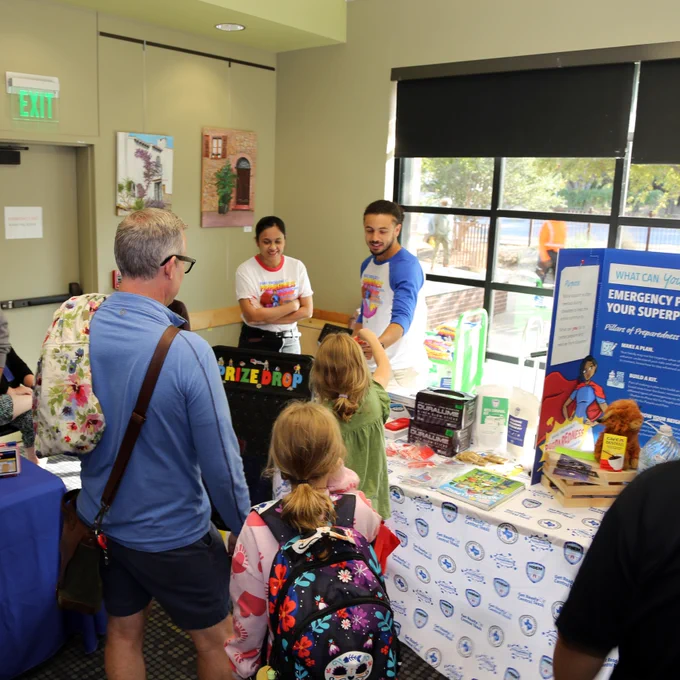 A photo showing a family playing a preparedness game at a Preparedness Pop-up event in a library.