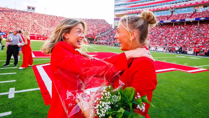 Homecoming royalty winners Claire Kelly (left) and Ava Hollingsworth, dressed in red and black formal attire, celebrate at midfield in Memorial Stadium. (Kristen Labadie/University Communication and Marketing)