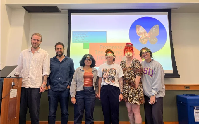 Morgan (far right) and her research group members in front of the title slide to their research presentation, "Progressive Insurgencies and Intersectional Backlash"
