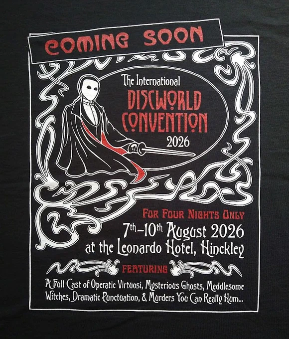 A photograph of a design: black background with art nouveaux border.  An oval with a man dressed as an opera ghost holding a sword is in the top of the design, next to it text in red reading "Coming Soon" underneath it "The International Discworld Convention 2026"  Beneath the detailing is more text "For Four Nights Only.  7th - 10th August 2026 at the Leonardo Hotel, Hinckley.  Featuring a full cast of operatic virtuosi, mysterious guests, meddlesome witches, dramatic punctuation and murders you can really hum"