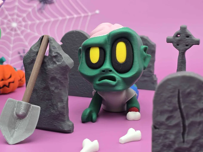 A 3D-printed Crawler Zombie with a cracked skull and exposed brain crawling among tombstones and bones on a pink graveyard setup.
