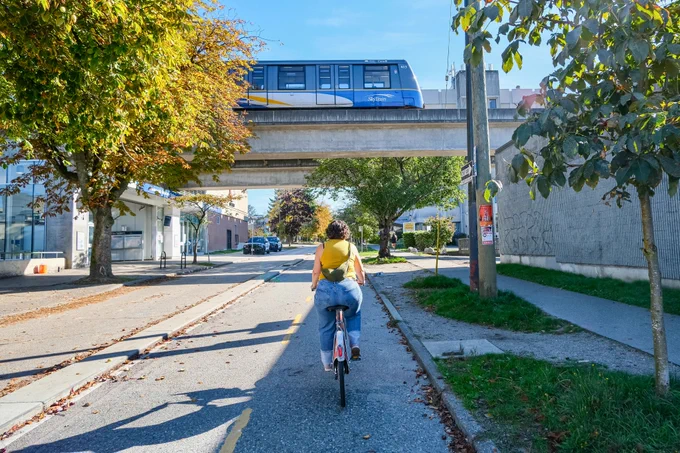 People of all ages and abilities ride bicycles on protected cycling infrastructure on the streets of Downtown Vancouver.