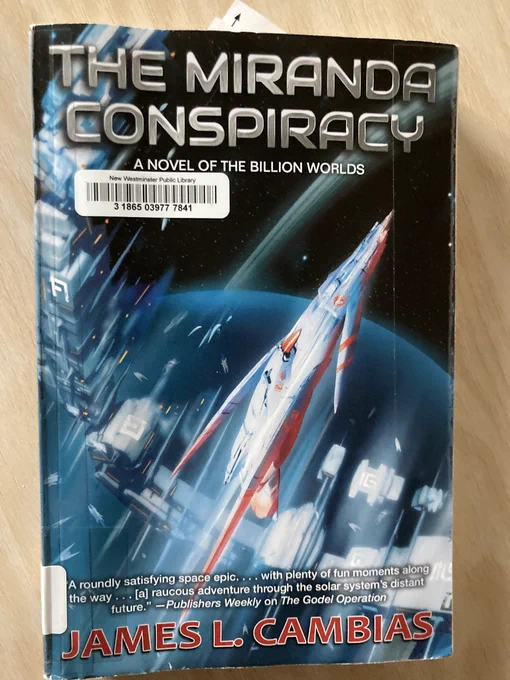 Picture of the book “The Mirandra Conspiracy” by James L. Cambias with a sticker that says it is from The New Westminster public library.