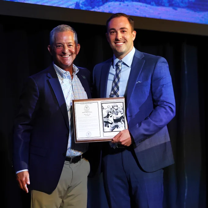 Justin Dvorak (R) is presented with his Hall of Fame plaque by athletic director David Hansburg (L)