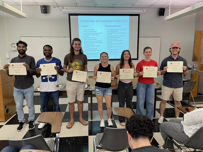 Seven School of Geosciences scholarship awardees holding their certificates.