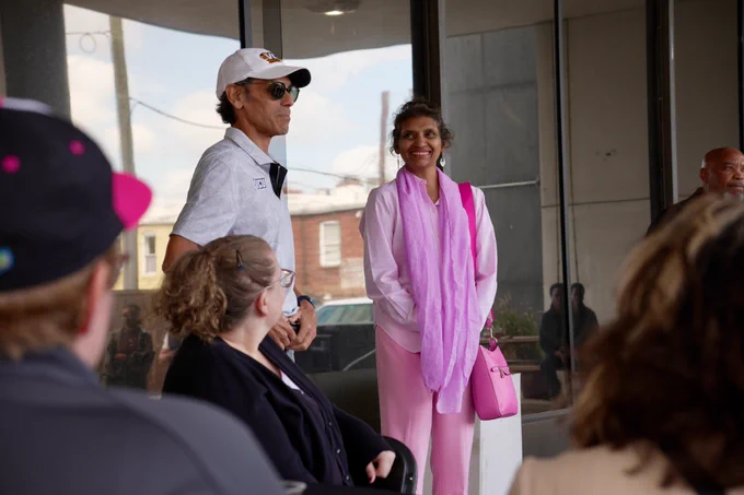 Monica Rao, wearing an all pink outfit, smiles as she watches Dr. Rao speak.
