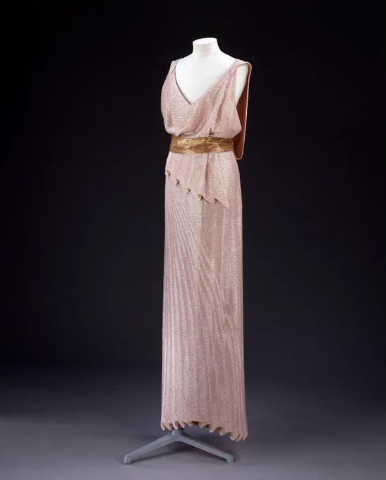 Full length view of the sleeveless pink and gold beaded evening dress with trompe l’oeil pleats and scoop neckline