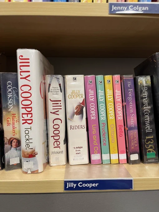 Photo of a row of books on a library shelf all by Jilly Cooper