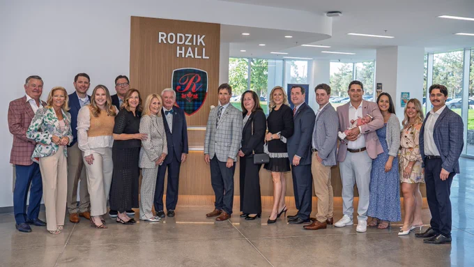 a group of Rodzik Family members standing in front of Rodzik Hall Crest