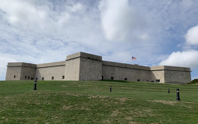 Fort under cloudy skies with American flag