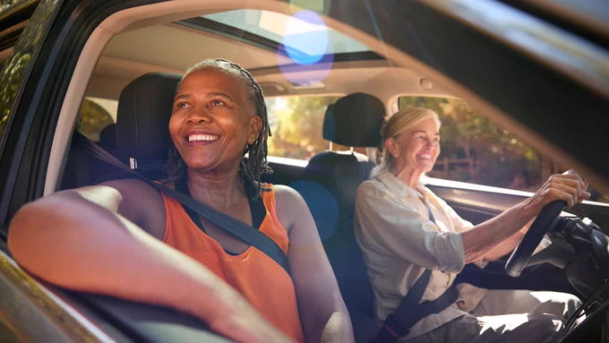 one woman driving another woman in car