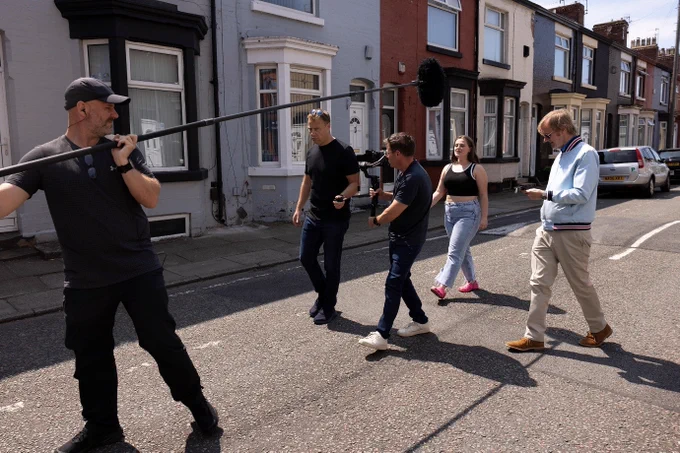 Filming taking place in a residential area on a sunny day.