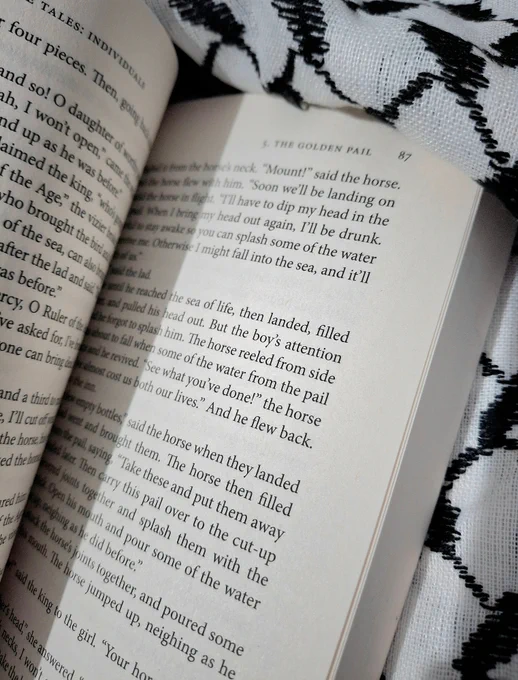  A photo of a book titled Speak Bird, Speak Again, opened on pages 86 and 87, with the title of the story The Golden Pail on the top right of the page.

