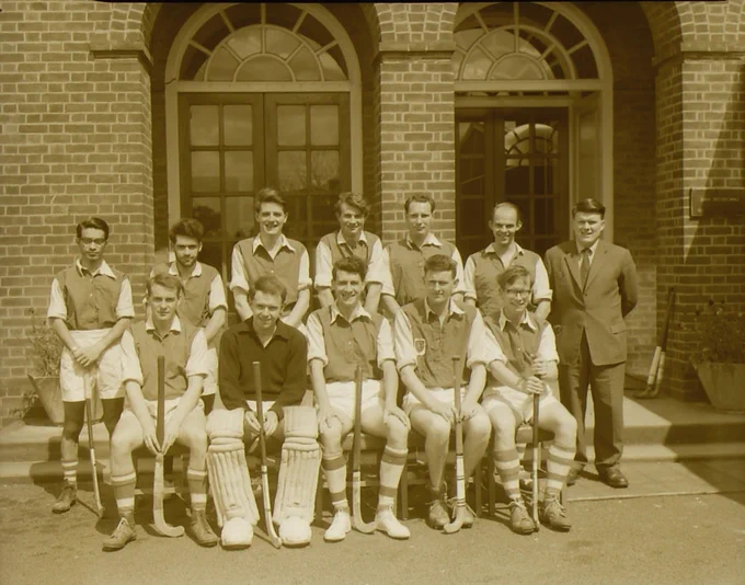 Black and white photograph of hockey team in front of Stafford Cripps building/