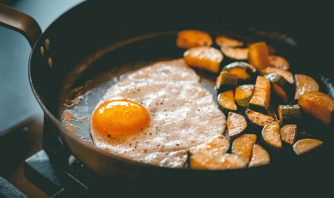 Frying pan containing fried egg and vegetables