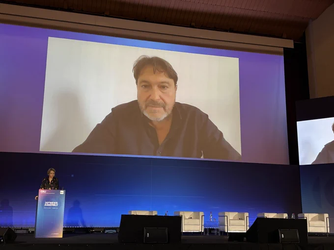 Man on a big screen in an auditorium