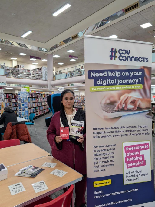 A member of the #CovConnects Team holding a National Databank SIM card and leaflet, ready to help you on your digital journey! 