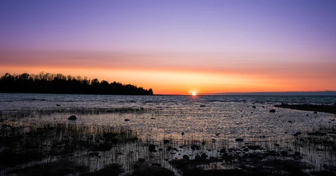 purple and orange skies over a sunset at merganser cove.