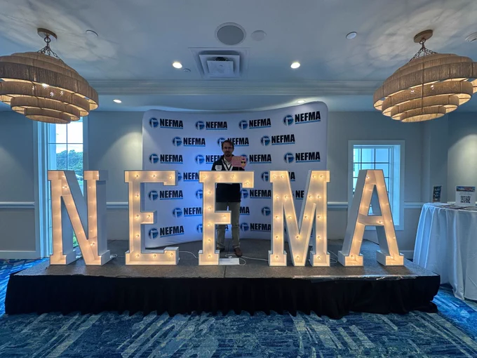 Bytes.co CEO & Co-Founder Jay Di Vece standing behind the NEFMA sign