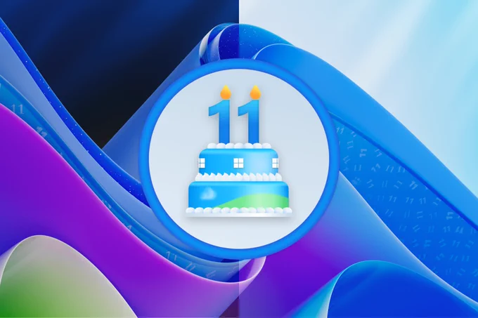 Two-tier cake with two candles on top forming the number 11 inside a circle placed on the Windows 11 Bloom waves.