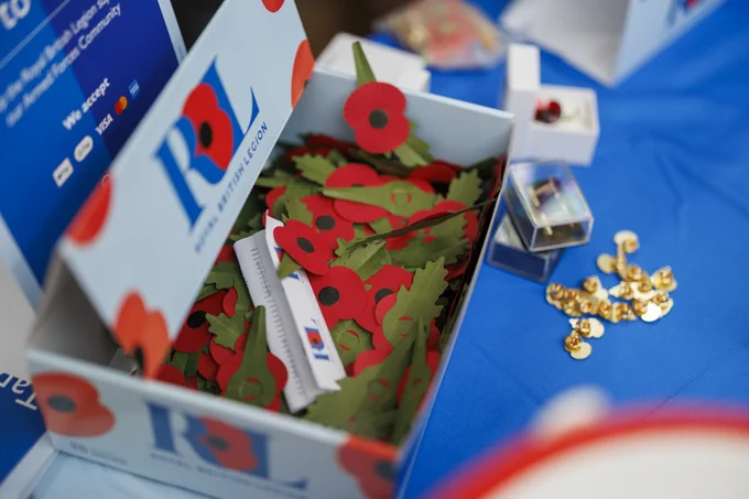 A Royal British Legion cardboard box with red poppies inside.