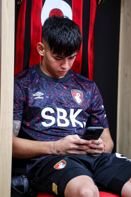 Julio Soler scrolls on his phone in the AFC Bournemouth dressing room.