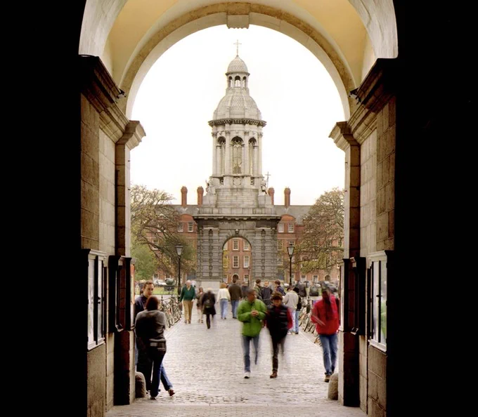 View through Front Gate archway showing people walking towards the Campanile inside the Front Square of Trinity College Dublin.