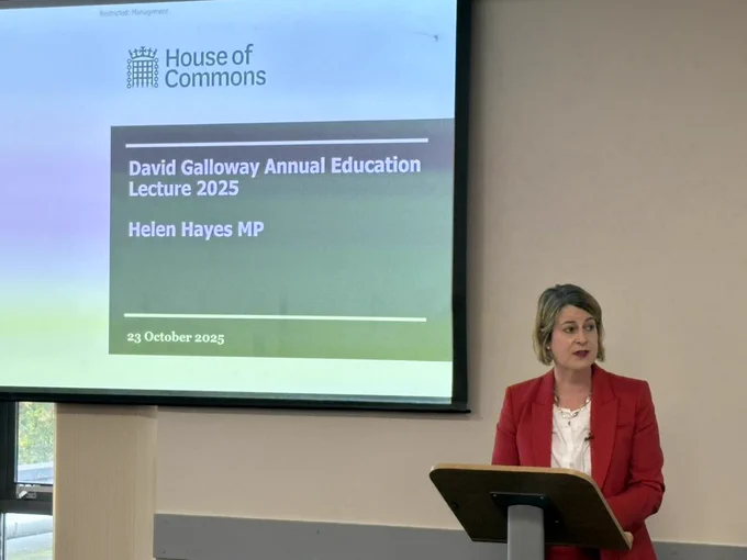 Helen Hayes MP at a lectern with a screen to her right with a slide stating ‘David Galloway Annual Education Lecture 2025’