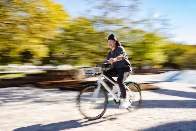 Student riding a bike by the Special Olympics Fountain on campus.