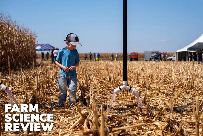 A child examines a piece of agricultural technology in a field at Farm Science Review.
