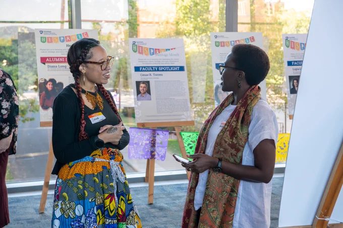 Two people talking to each other at the Hispanic Heritage Month celebration.