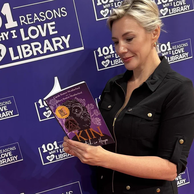 Morgan, State Librarian, is reading a book. 