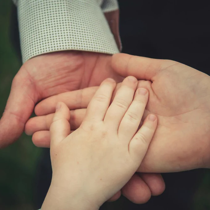 Photo by Andriyko Podilnyk on Unsplash shows 3 generations of hands 
