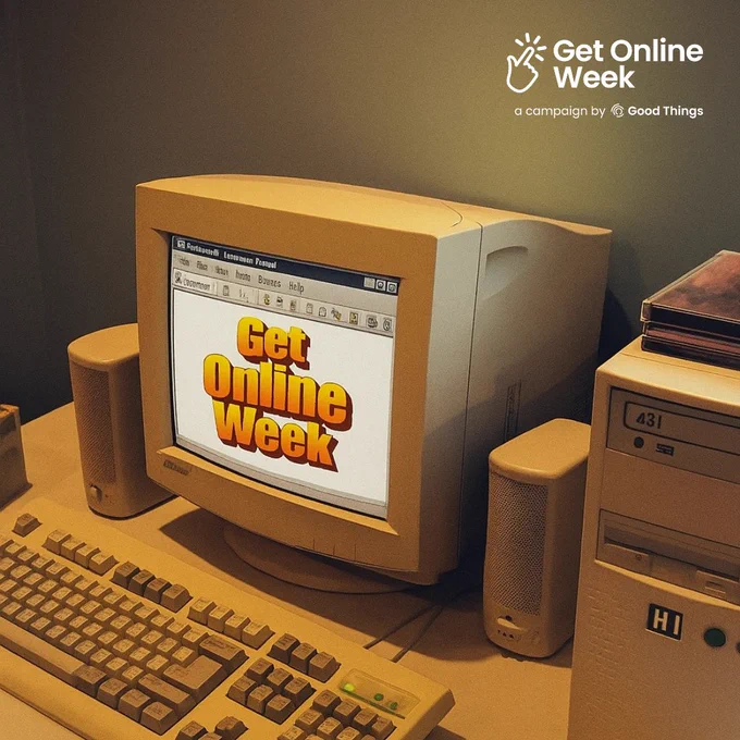 A computer, keyboard, speakers and a tower on a desk. Get Online Week campaign logo at the top right. Message on the screen in a Word Art font reads: "Get Online Week."
