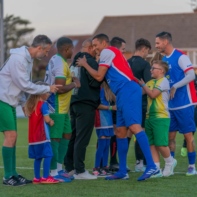 Gilberto Silva and Roberto Carlos embrace during the handshakes prior to kick-off at StriveAid