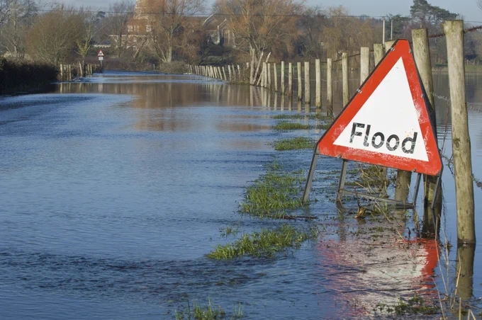 Image of a flood warning sign on a flooded country road