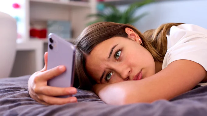 A teenage girl looking at her phone.