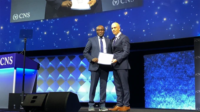 Shawn Hervey-Jumper, MD, (left) and Brain Nahed, MD, (right) pose for a photo with the award certificate.