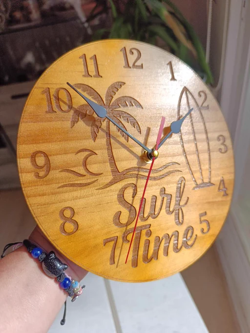 Reloj de pared de madera en tonos naturales, diseñado con un estilo surfero que evoca la playa. Ideal para decorar espacios interiores con un toque relajado y moderno.