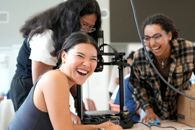 Three students smiling at a work station. (Photo by Adam Lau / UC Berkeley Engineering)