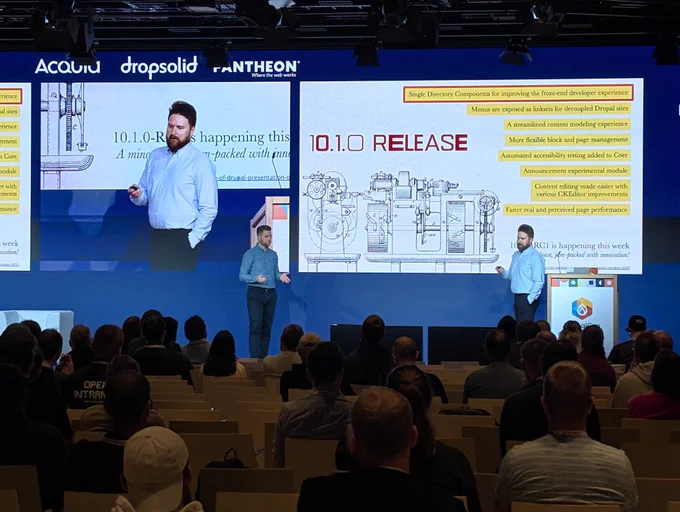 Presenter on stage discussing the 10.1.0 release features with a large audience in a conference setting.