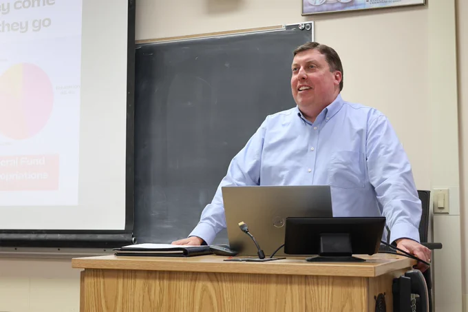 Wisconsin Representative Mark Born stands at a podium in a classroom.
