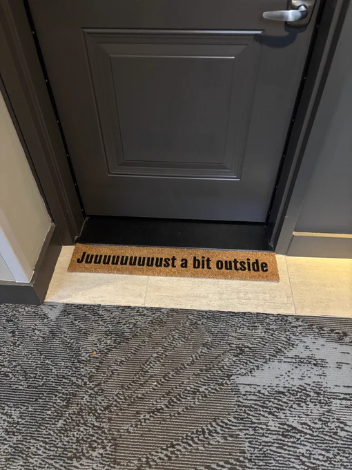 A small welcome mat that reads “juuuuuuuust a bit outside.”