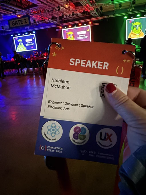 Holding up my speaker badge at the Codemotion venue