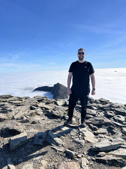 A photo of me standing at the summit of Snowdon.