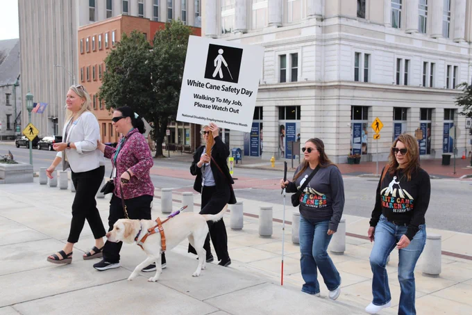 Group of individuals using white canes walk from the L&I building to the Capitol to celebrate White Cane Day. 