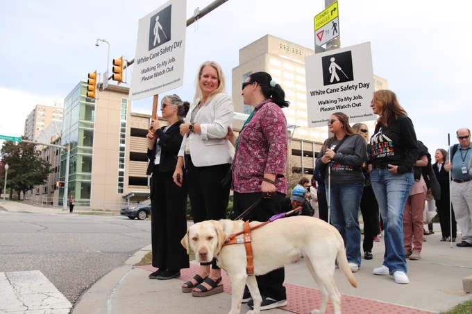 L&I Secretary Nancy A. Walker joined individuals using white canes for a walk from the L&I building to the Capitol to celebrate White Cane Day. Photo shows people waiting to cross the street.