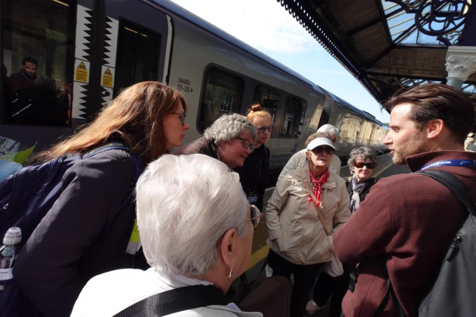 MySight York members are gathered on the platform around Rob from TransPennine Express as he is talking about the process of getting off the train.
